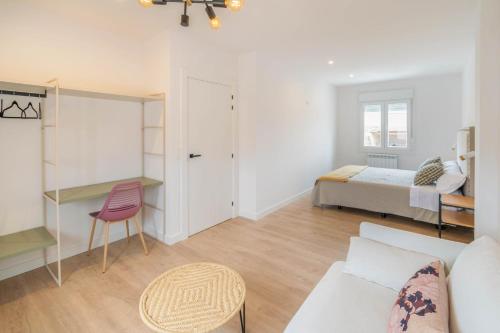 a living room with a bed and a couch at Acogedora casa para familias a 15 min de Bardenas in Fustiñana