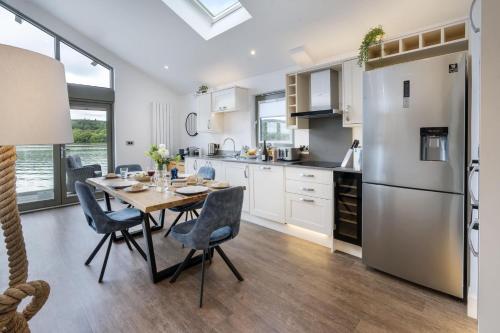 a kitchen with a table and a refrigerator at Hill Of Oaks in Windermere