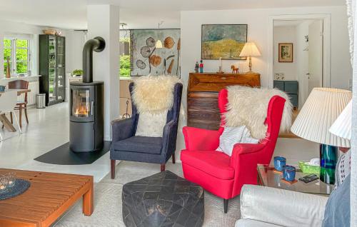 a living room with two chairs and a wood stove at Four Bedroom Nice Home In Gilleleje in Gilleleje