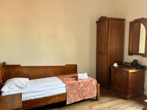 a bedroom with a bed and a dresser and a telephone at Zamek Golubski in Golub-Dobrzyń
