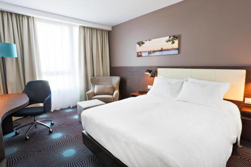 a hotel room with a bed and a desk and chair at OSKO Hôtel Toulouse Aéroport in Blagnac