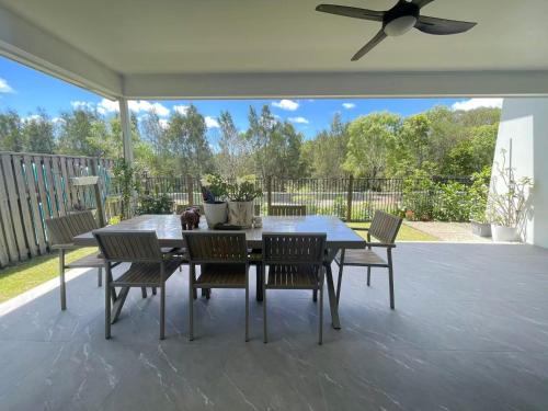 a dining table and chairs on a patio at Janie's Home in Pimpama