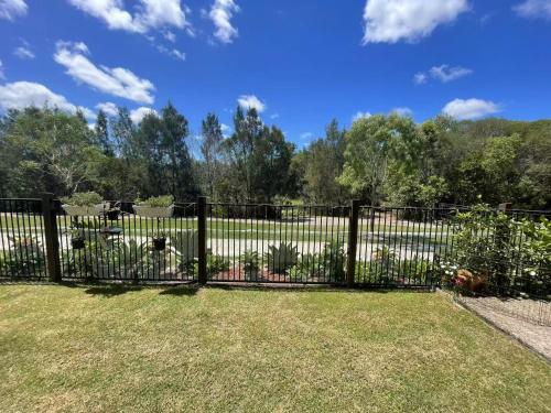 a black fence with plants in a yard at Janie's Home in Pimpama