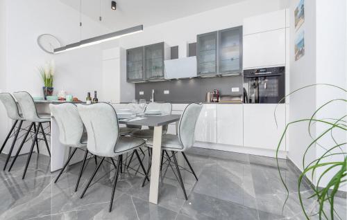 Una cocina con gabinetes blancos y una mesa y sillas. en 2 Bedroom Gorgeous Apartment In Zadar, en Zadar