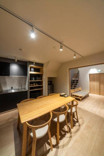 a kitchen and dining room with a wooden table and chairs at Utatei Mago in Takayama