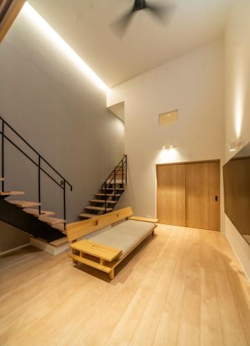 a large room with a bed and a staircase at Utatei Mago in Takayama