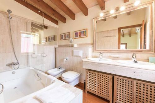 a bathroom with a tub and a sink and a toilet at Casita Luisa in Crestatx