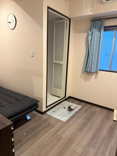 an empty room with a bed and a mirror at 依茶宿 in Matsudo