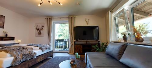 a living room with a couch and a tv at Apartment Schildenstein in Rottach-Egern