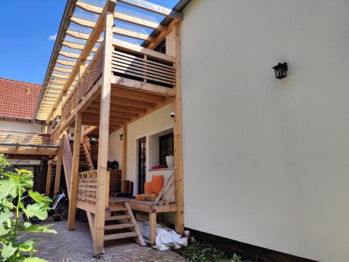 a building with a wooden deck and stairs on it at Haus Wiese & Lagune in Ettenheim