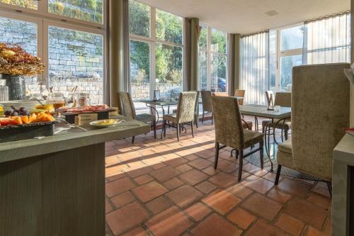 a dining room with a table and chairs and windows at Albergo-Toscana in Bad Schandau