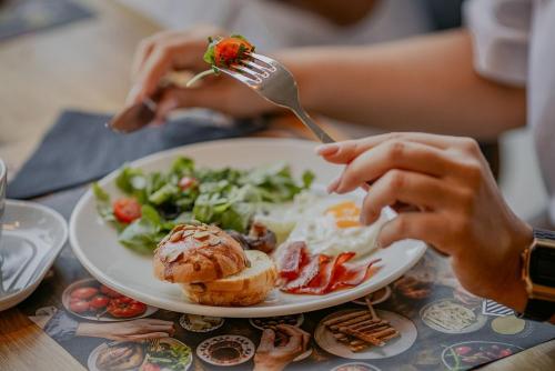 a person is eating a plate of breakfast food at Hotel Marina Club in Olsztyn