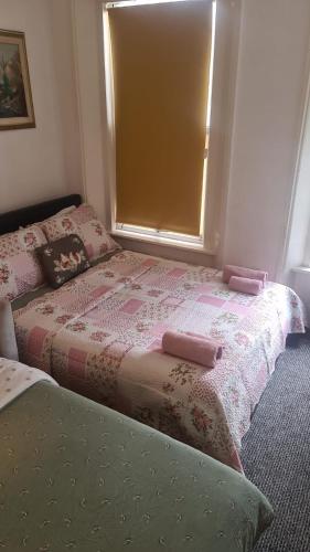 a bedroom with a bed with pink sheets and a window at Entire Cosy Flat in Central London in London
