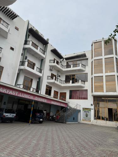 a large building with a parking lot in front of it at Hotel Samah in Mānsehra