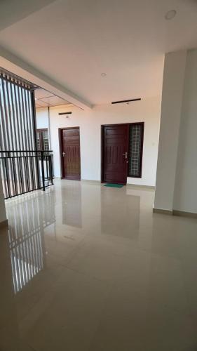 an empty room with two doors and a white floor at Ennckappallil complex Appartments in Rānī