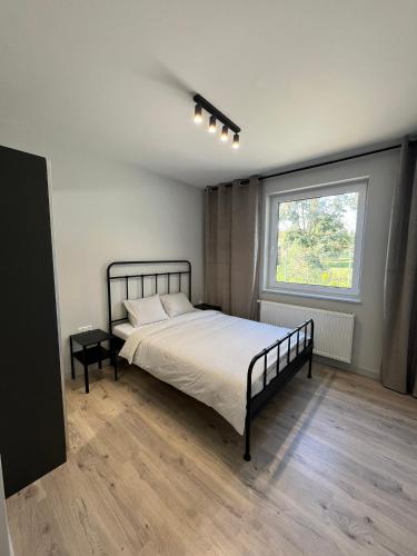 una camera da letto con un letto grande e una finestra di Property Apart - Work & Stay Suites a Breslavia