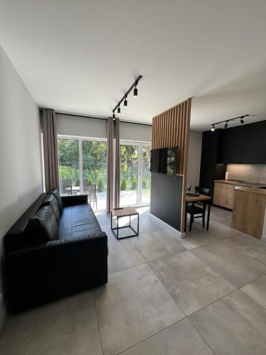 un salon avec un canapé noir et une table dans l'établissement Property Apart - Work & Stay Suites, à Wrocław
