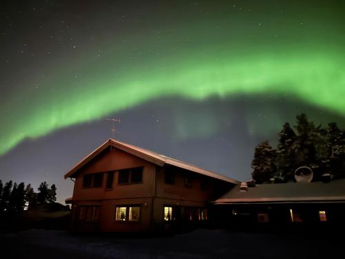 an image of the aurora borealis over a house at Målselvfossen Feriesenter in Bardufoss