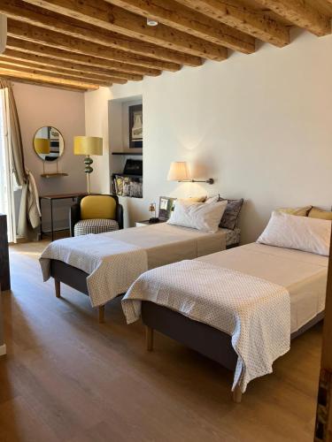 a bedroom with two beds and a chair at Sui tetti di Schio - Apartments guest house in Schio