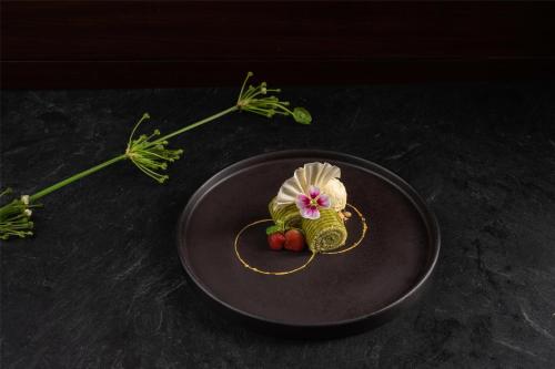 a plate with a flower and some vegetables on it at Conrad Bali in Nusa Dua