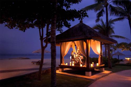 a gazebo on the beach at night at Conrad Bali in Nusa Dua
