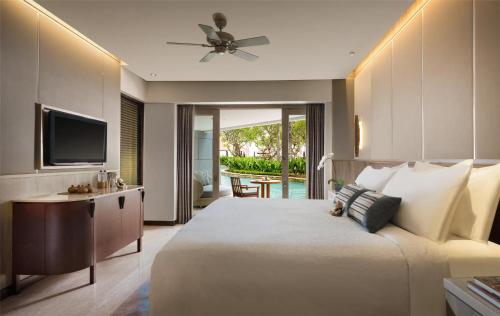 a bedroom with a large bed and a television at Conrad Bali in Nusa Dua