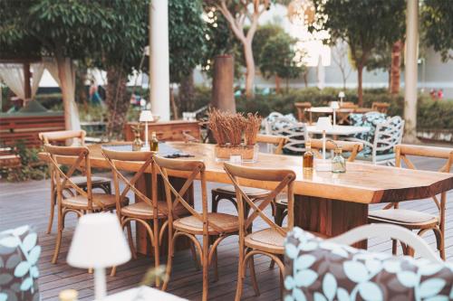 a wooden table and chairs on a patio at Conrad Dubai in Dubai