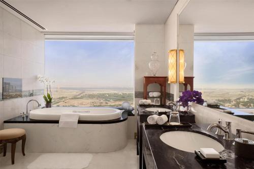 a bathroom with a tub and a large window at Conrad Dubai in Dubai
