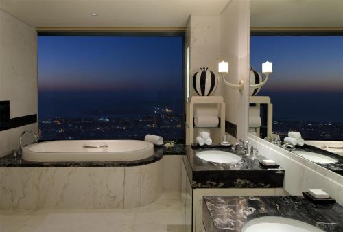 a bathroom with two sinks and a large window at Conrad Dubai in Dubai