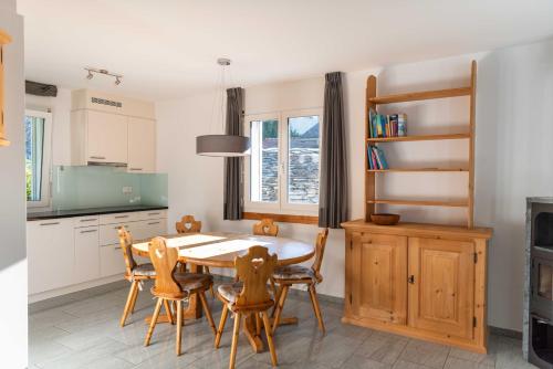 eine Küche mit Esstisch und Stühlen in der Unterkunft Ferienwohnung Mengelt, Splügen in Splügen