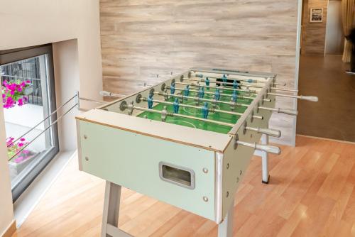 a foosball table in the middle of a room at Hotel Dolomiti Chalet in Vason