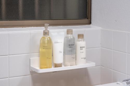 three bottles sitting on a shelf in a bathroom at Nagashima Onsen Villa Kuwana ,Family & Group Stay with Private Onsen in Kuwana