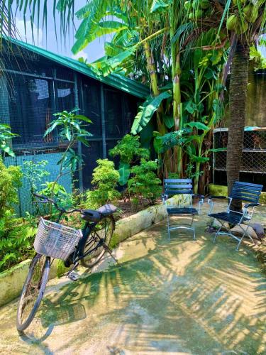 a bike parked in front of a building with chairs at Chill Door Homestay in Ấp Long Ðại
