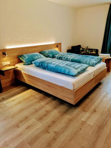 a bedroom with a bed with blue pillows on it at Gasthaus Linde Ingelfingen in Ingelfingen