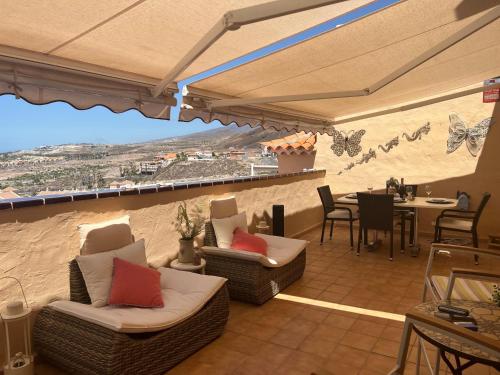 a patio with chairs and a table with a view at Apartamentos The Heights - Los Cristianos in Los Cristianos