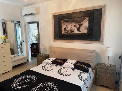 a bedroom with a bed and a painting on the wall at SUITE FLORE - Oasi di Relax in un elegante VILLA in Genova