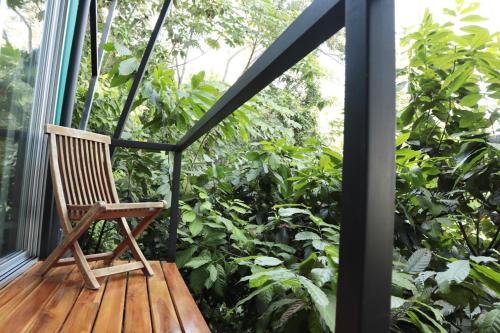 a rocking chair sitting on a porch with a garden at The Emerald Haven in Parrita