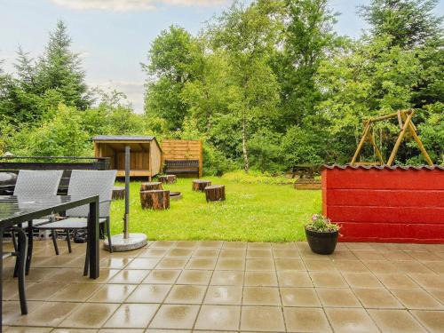 a patio with a table and chairs and a yard at 6 person holiday home in Ulfborg-By Traum in Ulfborg