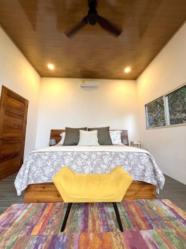 a bedroom with a large bed with a yellow bench at The Emerald Haven in Parrita