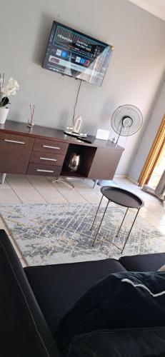 a living room with a desk and a chair at Bandile's cosy home in Honeydew