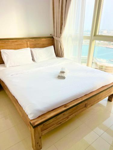 a bed in a room with a large window at Reem Island, Unique furnished one bedroom with amazing seaview in Abu Dhabi