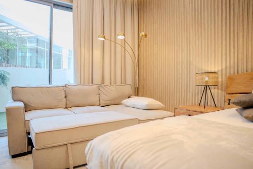 a living room with a couch and a bed at Luxurious studio apartment with private garden in Sharjah