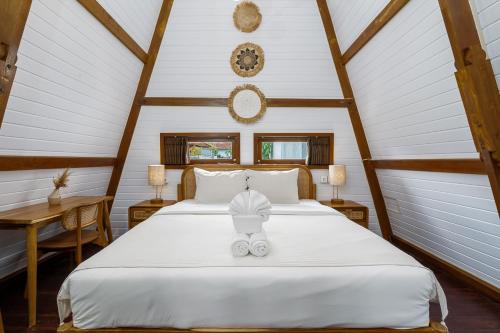a bedroom with a white bed in a attic at Alamora Villa - New Stylish 1BR Villa, Canggu in Dalung
