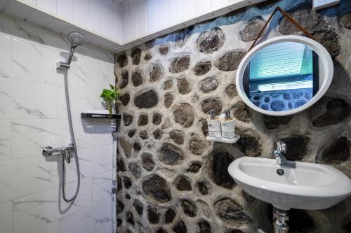 a stone bathroom with a sink and a mirror at Alamora Villa - New Stylish 1BR Villa, Canggu in Dalung