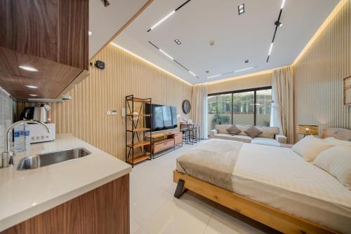 a bedroom with a bed and a sink and a couch at Luxurious studio apartment with private garden in Sharjah