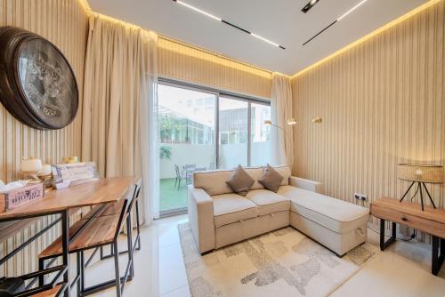 a living room with a couch and a table at Luxurious studio apartment with private garden in Sharjah