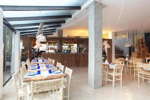 a restaurant with tables and chairs and a bar at Apartamentos Castaví in Es Pujols