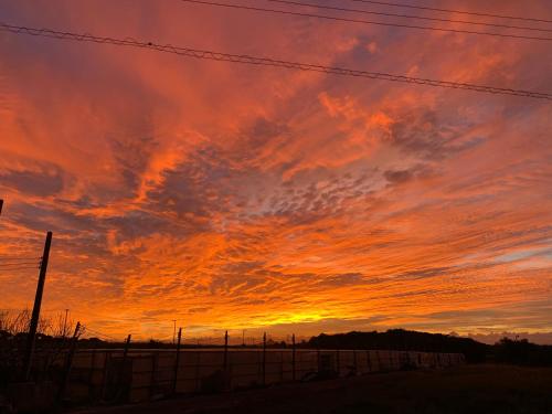 a sunset over a field with a fence at Guest House Isa in Motobu
