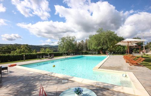 a large swimming pool with chairs and an umbrella at Amazing Home In Giungano in Giungano