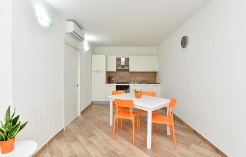 a kitchen and dining room with a white table and orange chairs at Amazing Home In Giungano in Giungano